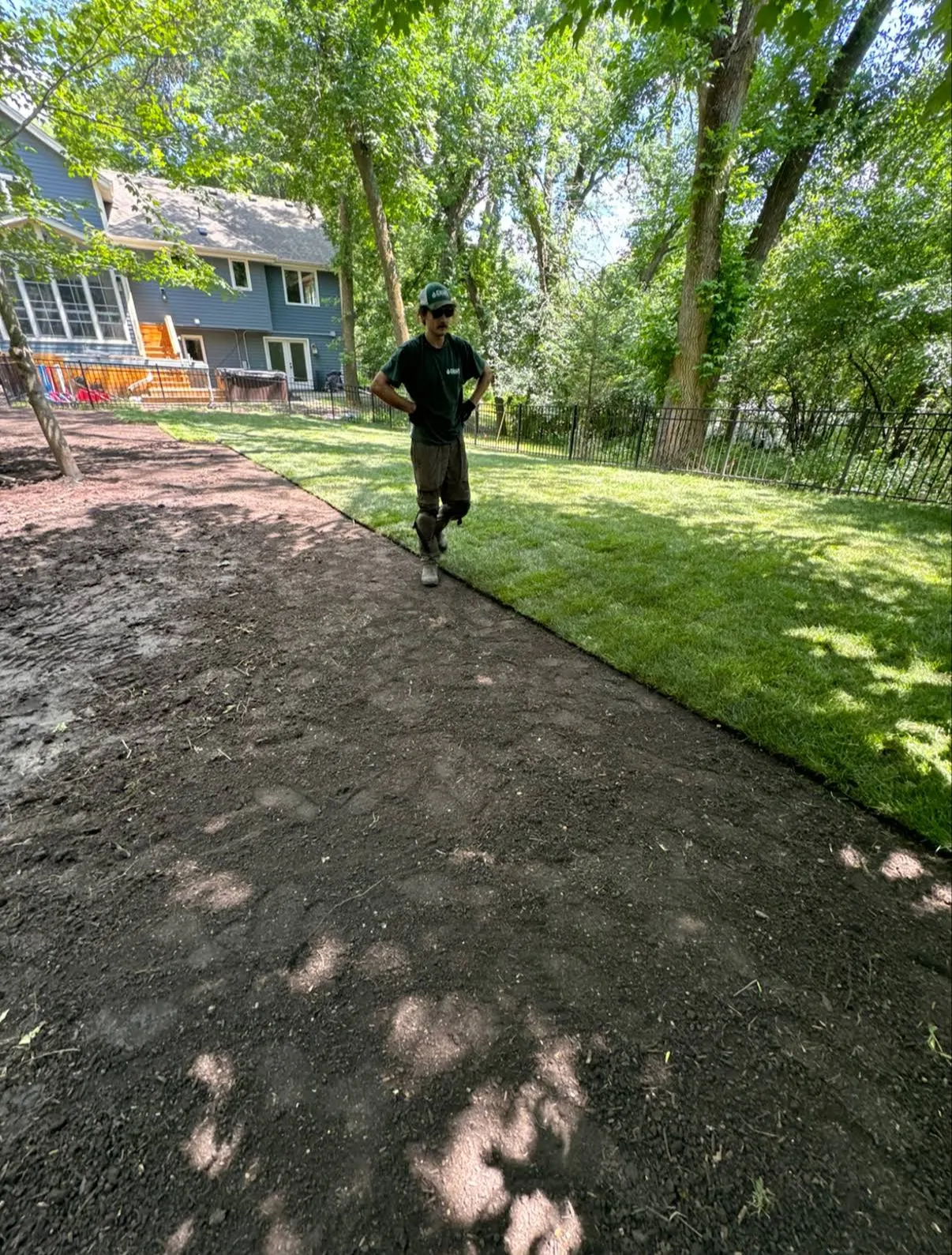 Crew member prepping soil for sod installation